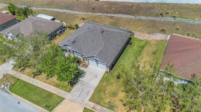 an aerial view of house with yard and ocean view
