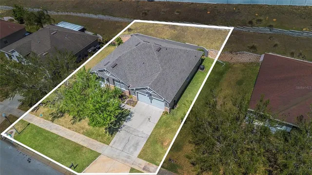 an aerial view of a house with a yard