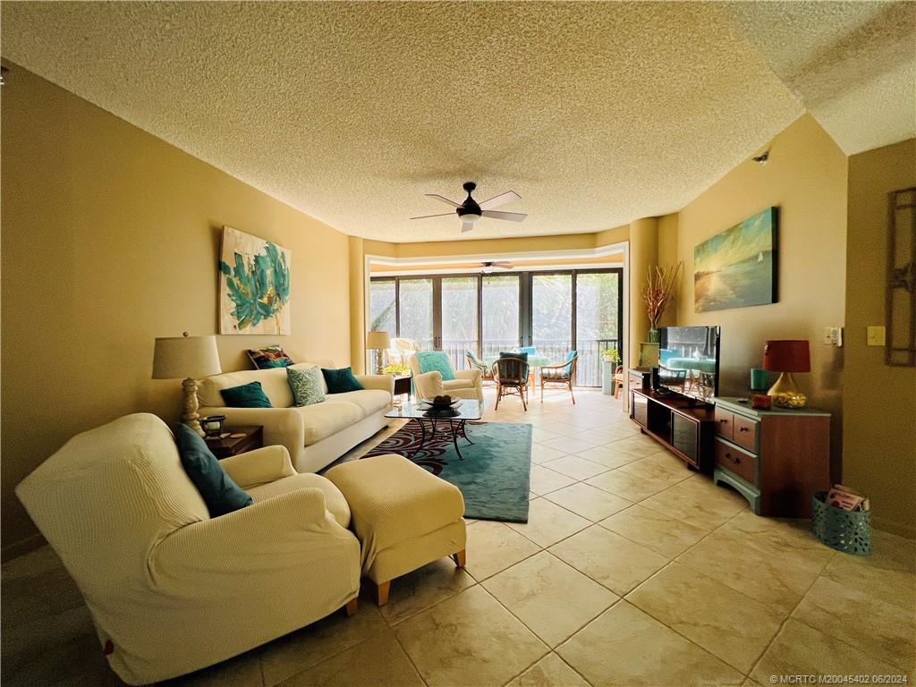 221 Northeast Plantation Road, Unit 215 Stuart, FL 34996 - Photo 13 of 83 a living room with furniture and a flat screen tv