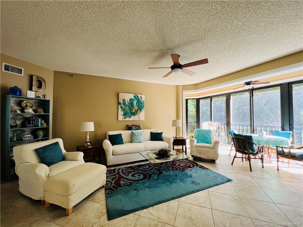 221 Northeast Plantation Road, Unit 215 Stuart, FL 34996 - Photo 14 of 83 a living room with furniture and a large window
