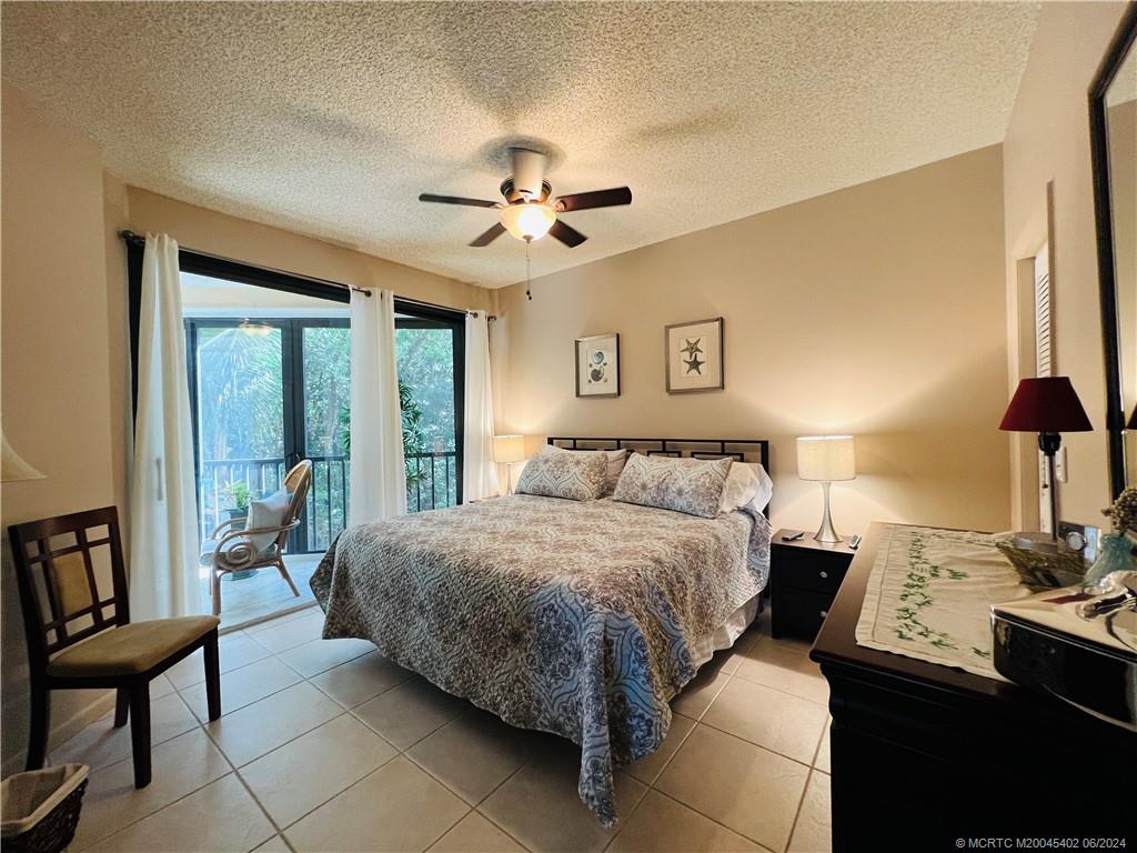 221 Northeast Plantation Road, Unit 215 Stuart, FL 34996 - Photo 27 of 83 a bedroom with a bed and a chandelier
