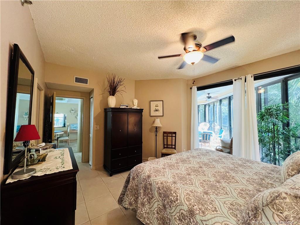 221 Northeast Plantation Road, Unit 215 Stuart, FL 34996 - Photo 28 of 83 a bedroom with a bed and a dresser