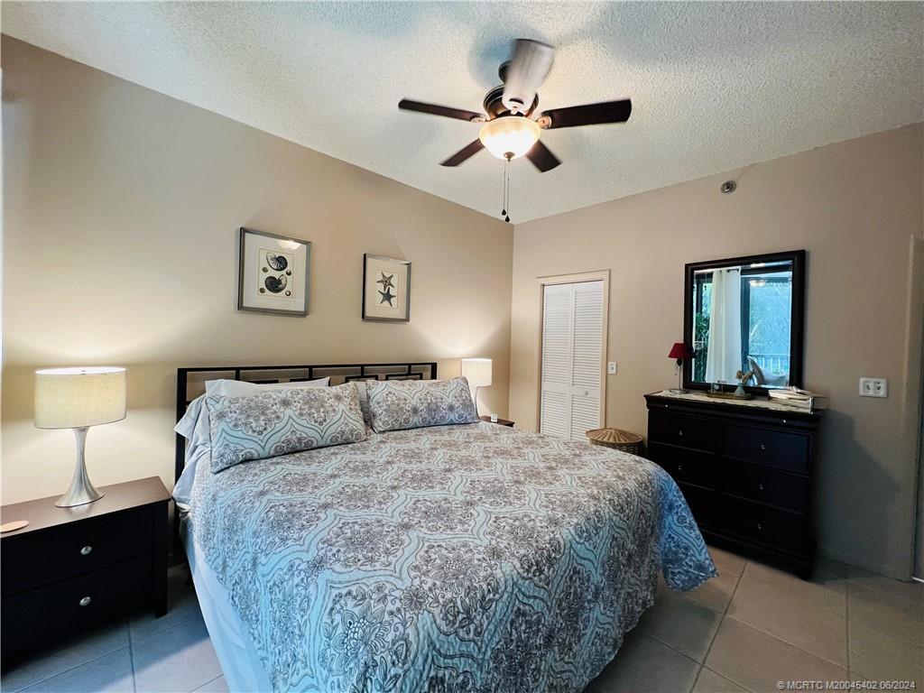 221 Northeast Plantation Road, Unit 215 Stuart, FL 34996 - Photo 31 of 83 a bedroom with a bed and a chandelier