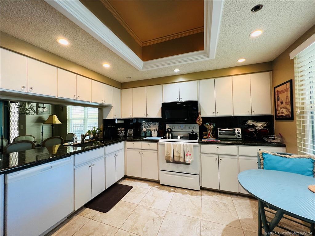 221 Northeast Plantation Road, Unit 215 Stuart, FL 34996 - Photo 41 of 83 a kitchen with stainless steel appliances granite countertop a sink and cabinets
