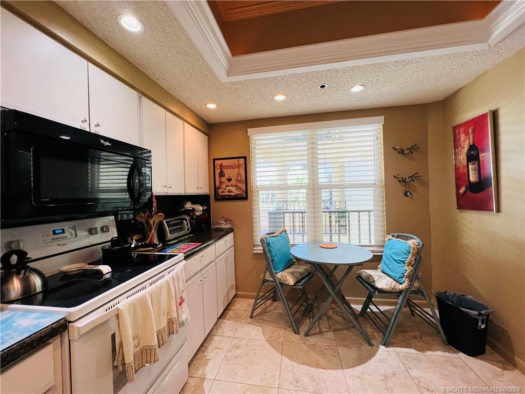 221 Northeast Plantation Road, Unit 215 Stuart, FL 34996 - Photo 45 of 83 a kitchen with stainless steel appliances kitchen island granite countertop a sink and a stove top oven