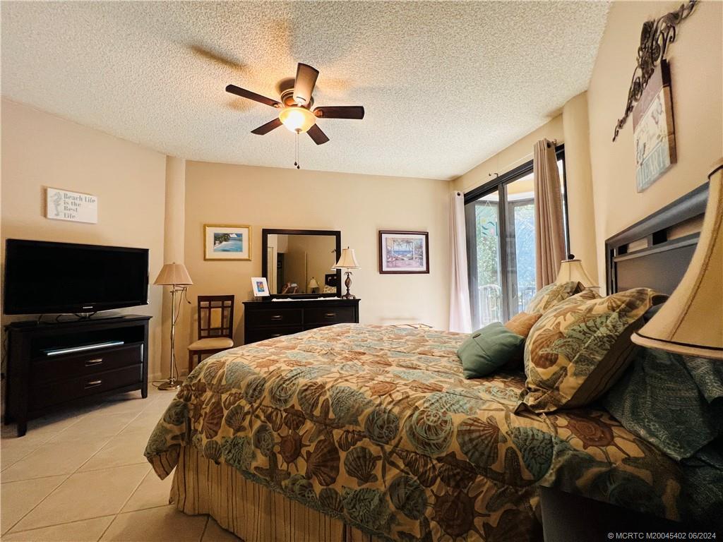 221 Northeast Plantation Road, Unit 215 Stuart, FL 34996 - Photo 49 of 83 a bedroom with a bed and a flat screen tv