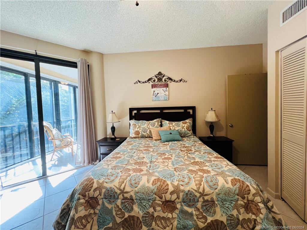 221 Northeast Plantation Road, Unit 215 Stuart, FL 34996 - Photo 51 of 83 a bedroom with a large bed and a large window