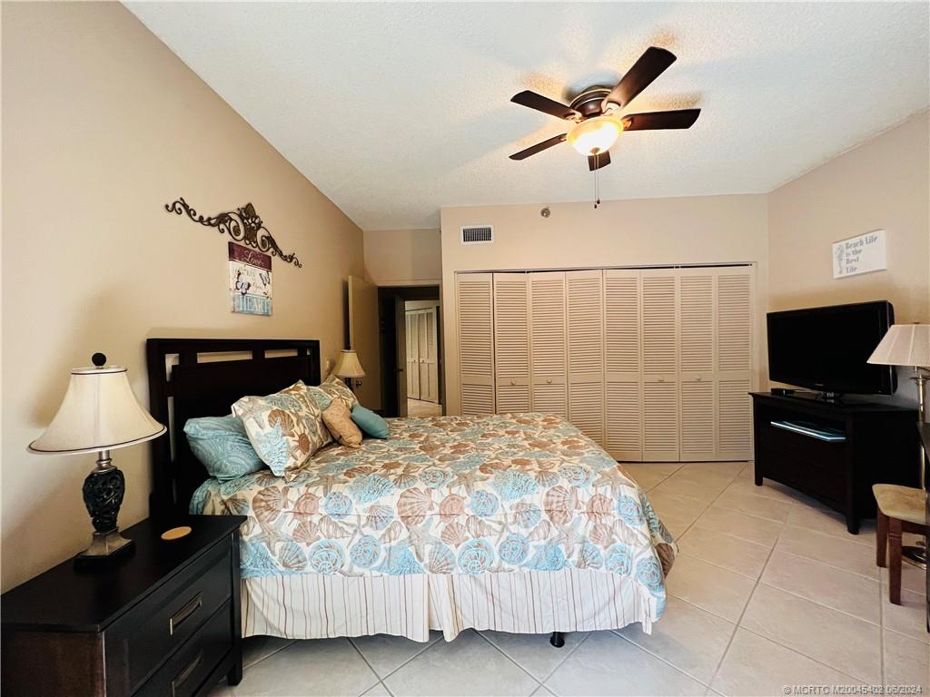 221 Northeast Plantation Road, Unit 215 Stuart, FL 34996 - Photo 53 of 83 a bedroom with a bed and a television