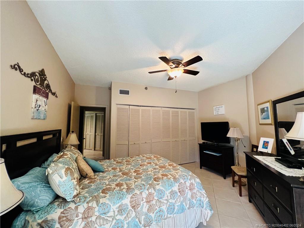 221 Northeast Plantation Road, Unit 215 Stuart, FL 34996 - Photo 54 of 83 a bedroom with a bed and a flat screen tv
