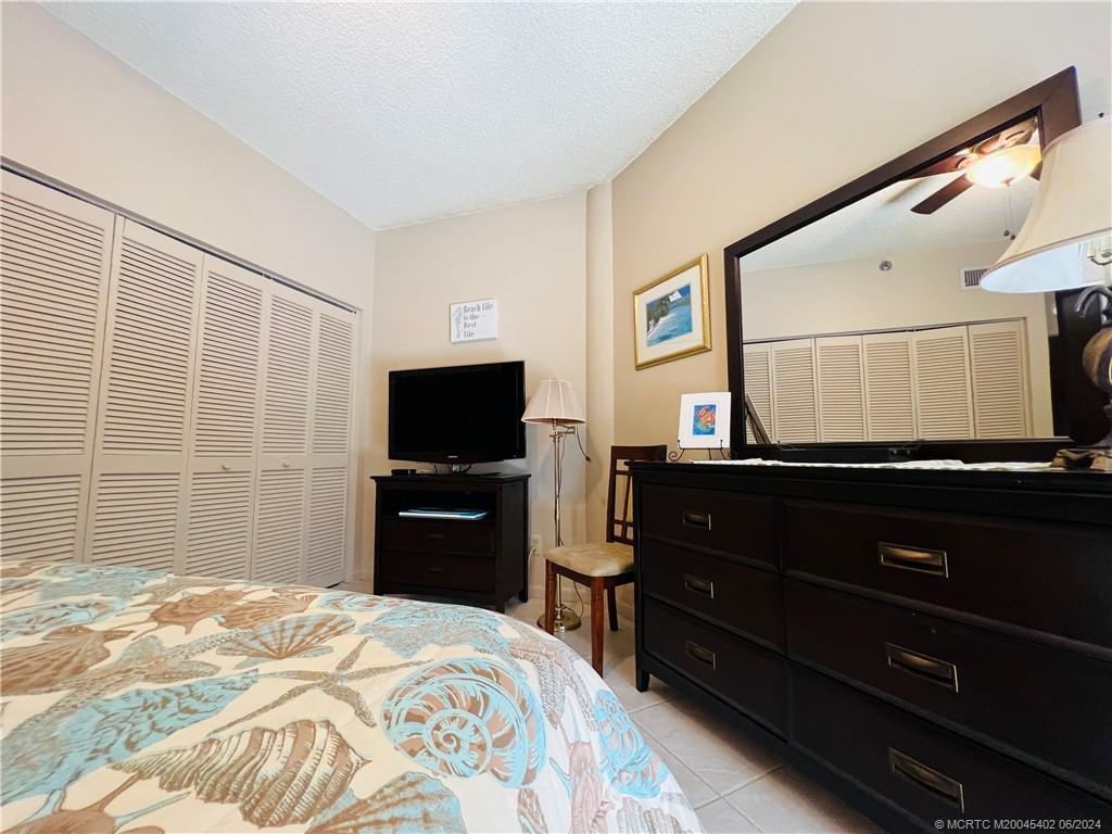 221 Northeast Plantation Road, Unit 215 Stuart, FL 34996 - Photo 55 of 83 a bedroom with a bed and a flat screen tv