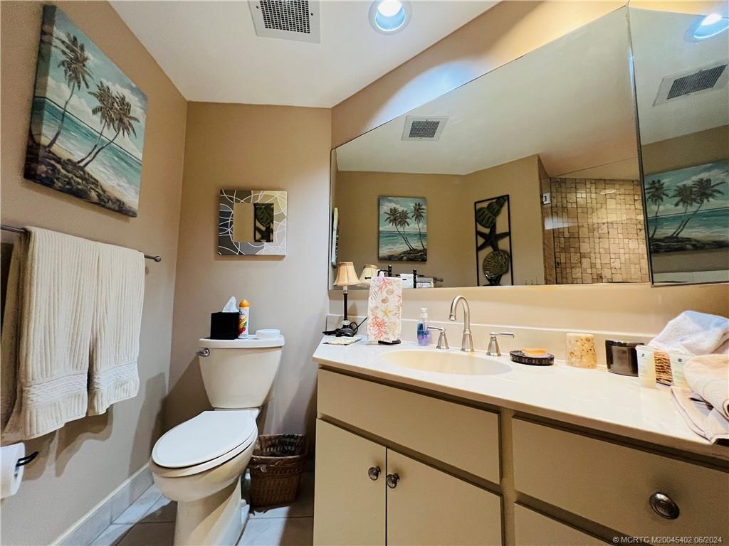 221 Northeast Plantation Road, Unit 215 Stuart, FL 34996 - Photo 59 of 83 a bathroom with a toilet sink and mirror