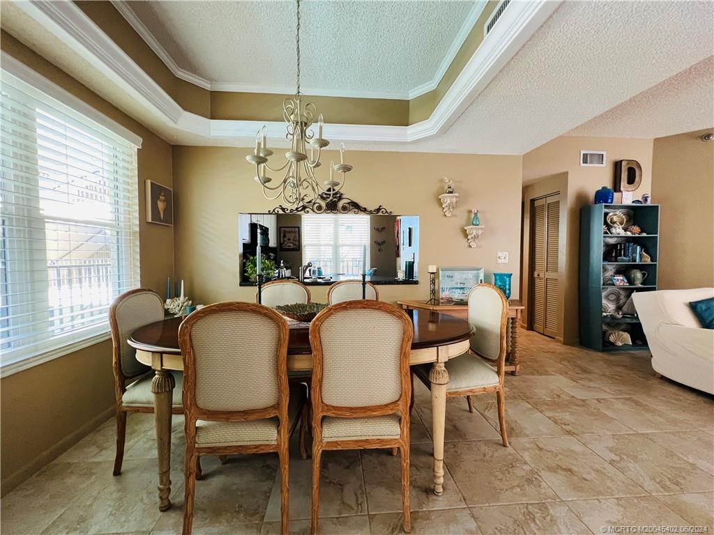 221 Northeast Plantation Road, Unit 215 Stuart, FL 34996 - Photo 9 of 83 a view of a dining room with furniture and a chandelier