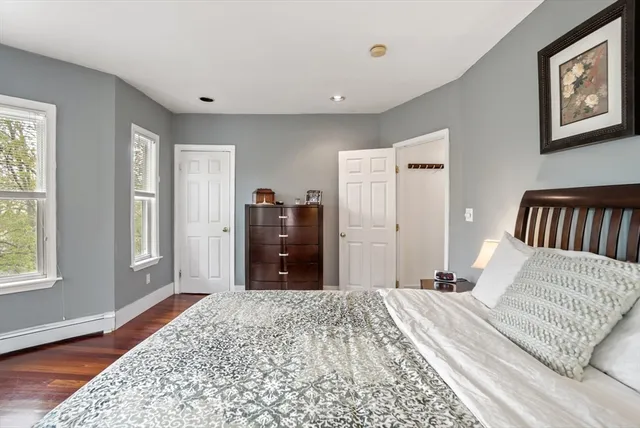 a bedroom with a bed closet and wooden floor