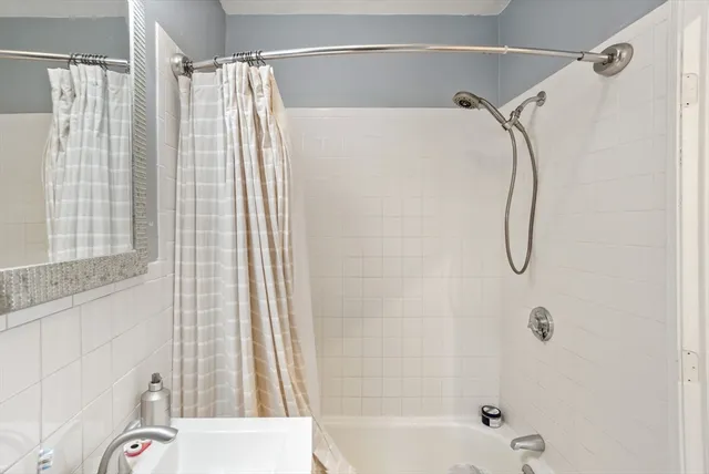 a bathroom with a shower curtain and a shower