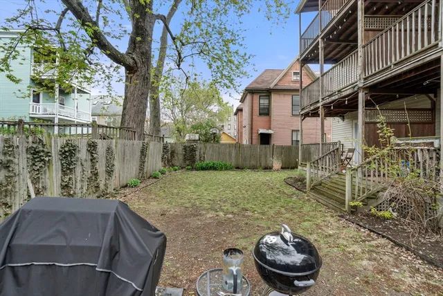 a backyard of a house with table and chairs