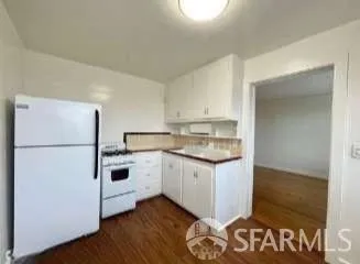 a kitchen with white cabinets and white appliances