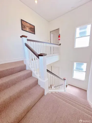 a view of staircase with white walls and windows