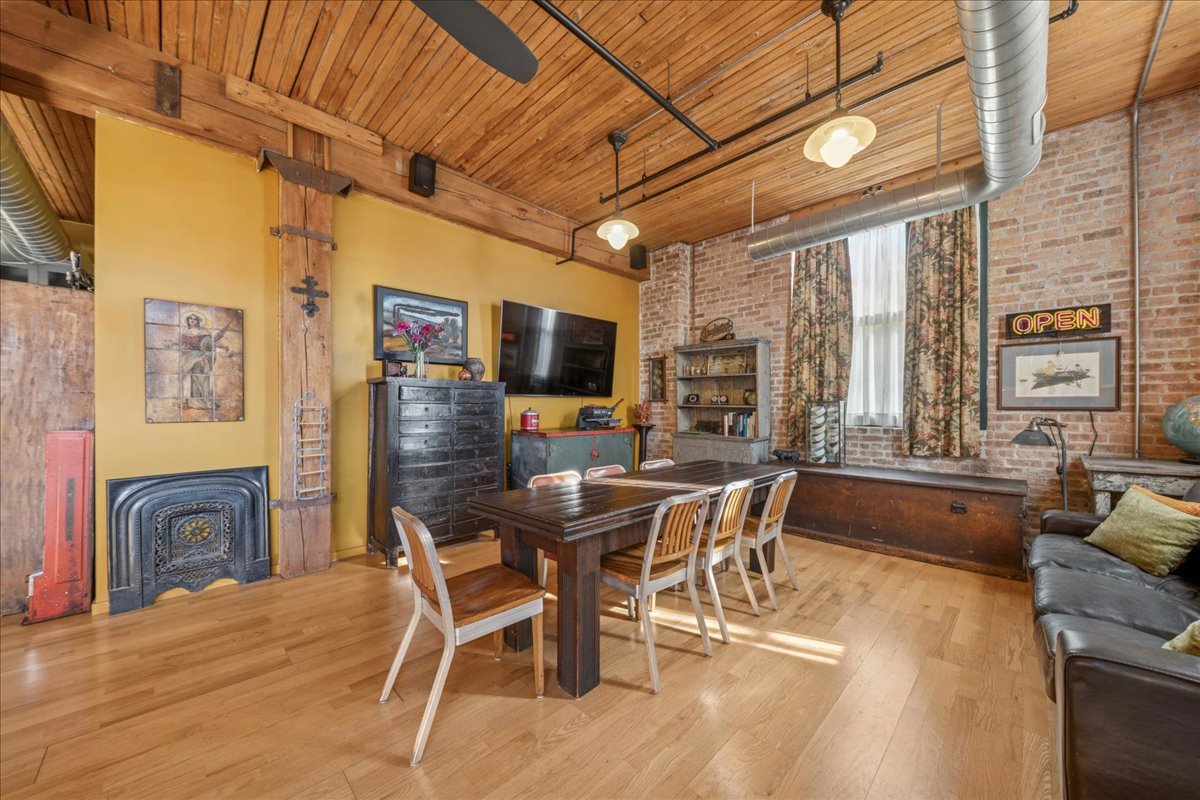 3500 South Sangamon Street, Unit 109 Chicago, IL 60609 - Photo 6 of 23 a dining room with furniture a flat screen tv and wooden floor