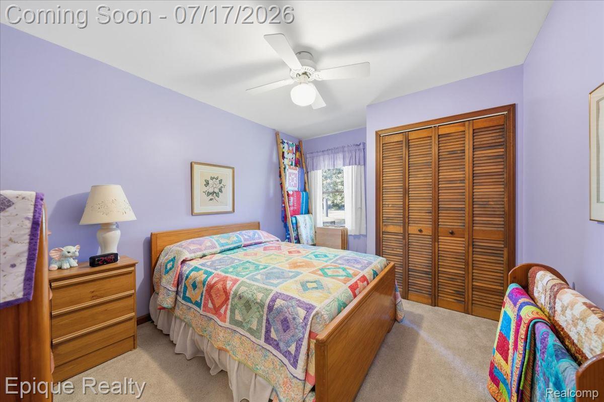 555 East Square Lake Road Troy, MI 48085 - Photo 25 of 48 Carpeted room featuring a ceiling fan, a window with sheer curtains, and louvered bi-fold closet doors
