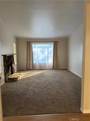 an empty room with fireplace and windows