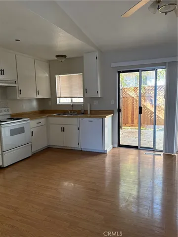 a large kitchen with granite countertop a sink window and cabinets