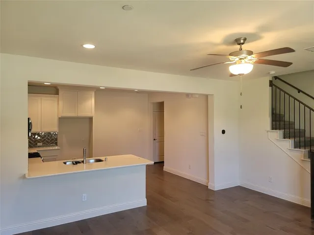 a living room with hardwood floor and a ceiling fan