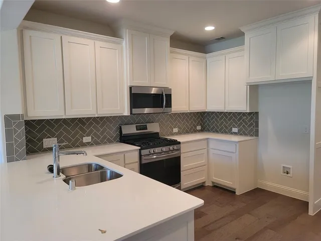 a kitchen with a sink a stove and cabinets