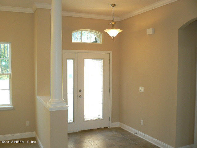 155 Irish Rose Road St. Augustine, FL 32092 - Photo 4 of 34 a view of a hallway with a wooden door