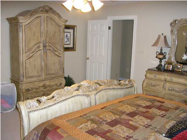 2594 Cove Road Navarre, FL 32566 - Photo 14 of 18 a bedroom with a bed and a chandelier