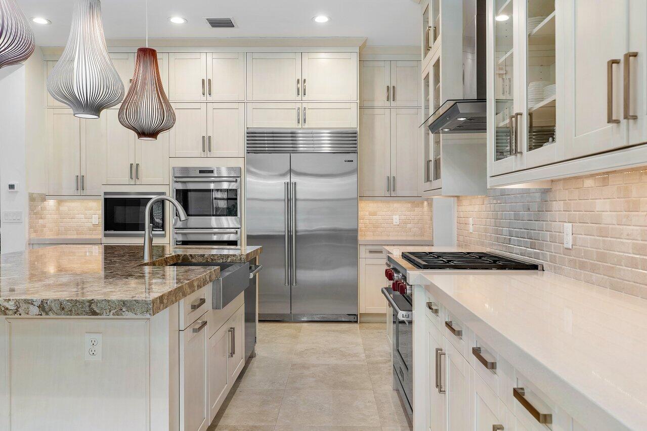 17662 Cadena Drive Boca Raton, FL 33496 - Photo 32 of 71 a kitchen with stainless steel appliances granite countertop a sink a stove and a refrigerator