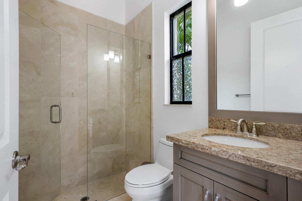17662 Cadena Drive Boca Raton, FL 33496 - Photo 37 of 71 a bathroom with a granite countertop sink toilet a mirror and shower