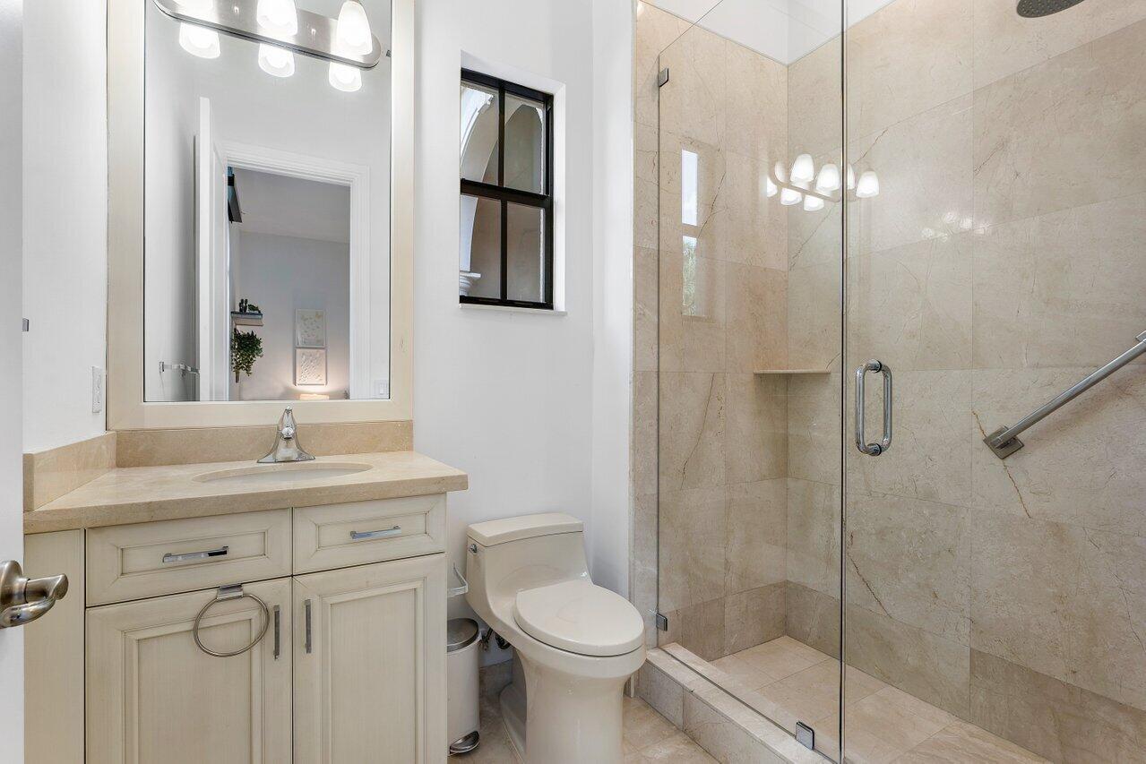 17662 Cadena Drive Boca Raton, FL 33496 - Photo 38 of 71 a bathroom with a toilet sink vanity granite and shower