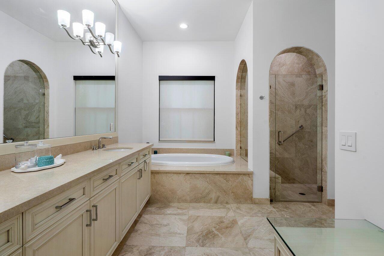 17662 Cadena Drive Boca Raton, FL 33496 - Photo 41 of 71 a spacious bathroom with a granite countertop sink a mirror a shower and a bathtub