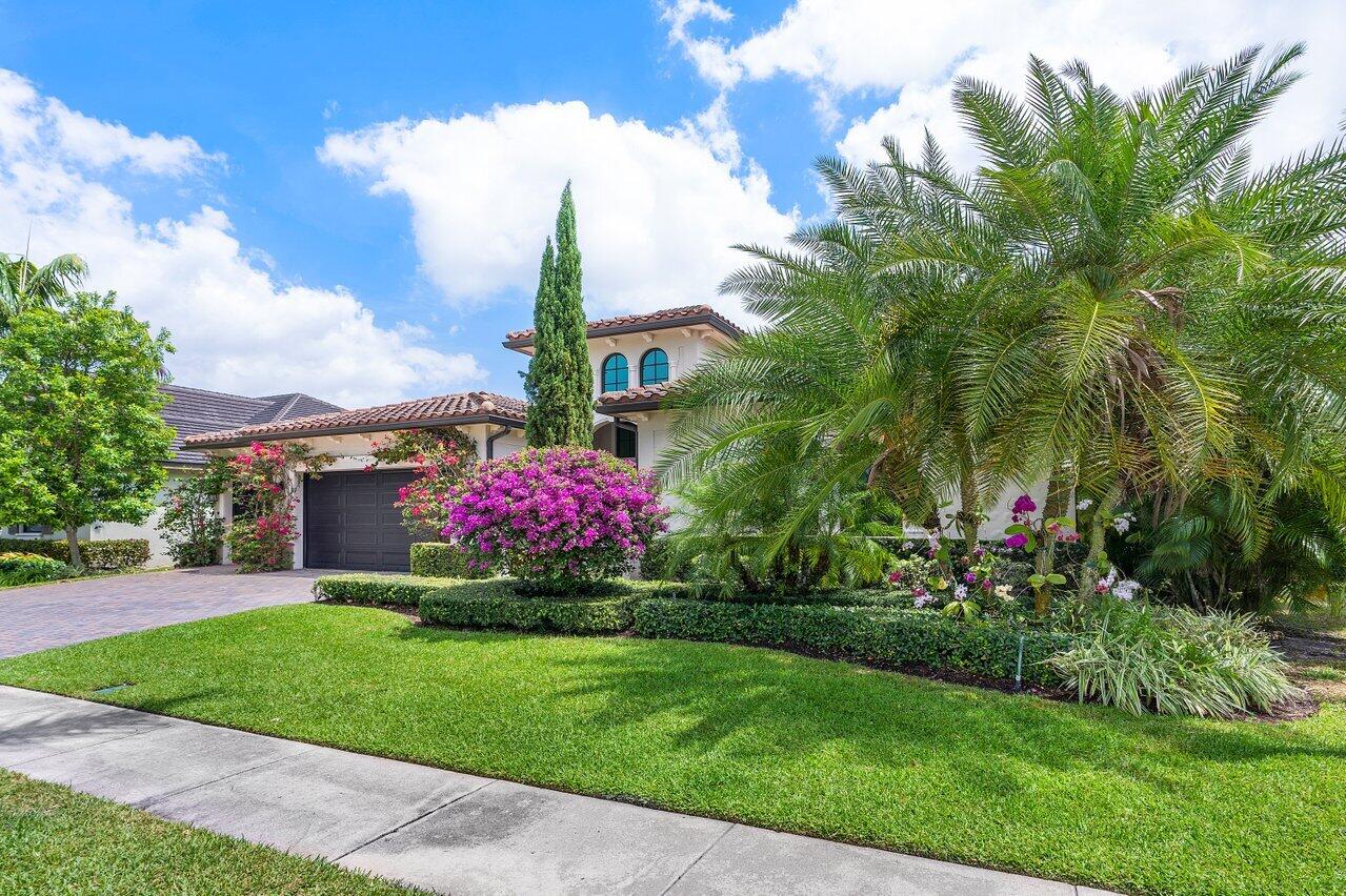 17662 Cadena Drive Boca Raton, FL 33496 - Photo 49 of 71 a front view of a house with a yard and fountain in middle
