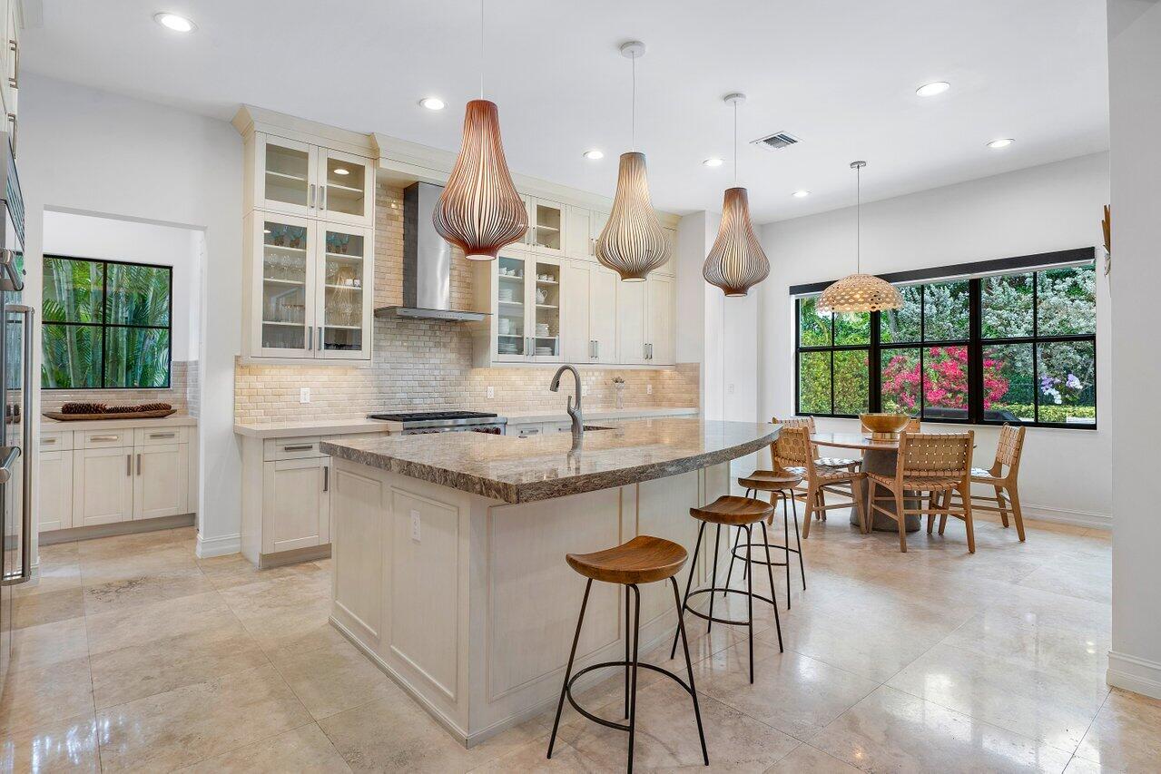 17662 Cadena Drive Boca Raton, FL 33496 - Photo 5 of 71 a kitchen with stainless steel appliances kitchen island granite countertop a table and chairs in it