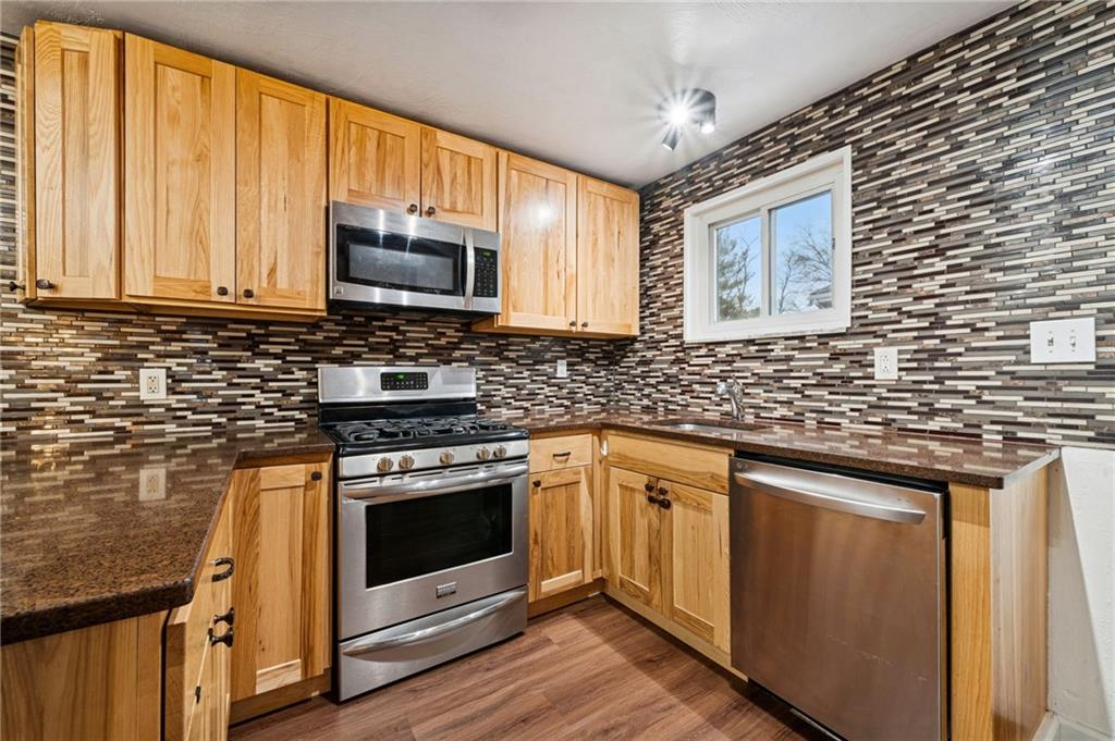 910 Colonial Manor Road Irwin, PA 15642 - Photo 13 of 40 a kitchen with stainless steel appliances granite countertop a stove microwave and cabinets