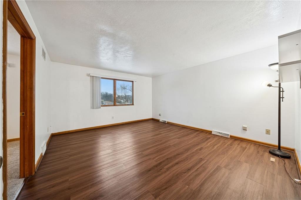 910 Colonial Manor Road Irwin, PA 15642 - Photo 17 of 40 a view of an empty room with wooden floor and a window