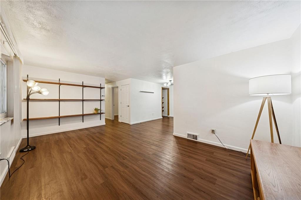 910 Colonial Manor Road Irwin, PA 15642 - Photo 7 of 40 an empty room with wooden floor and cabinet