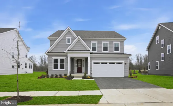 a front view of a house with a garden and yard