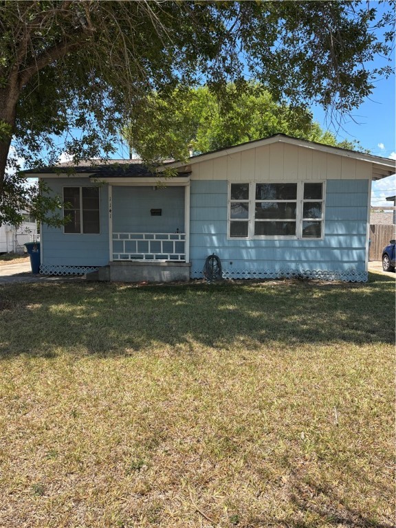 a view of a yard in front of a house with large tree