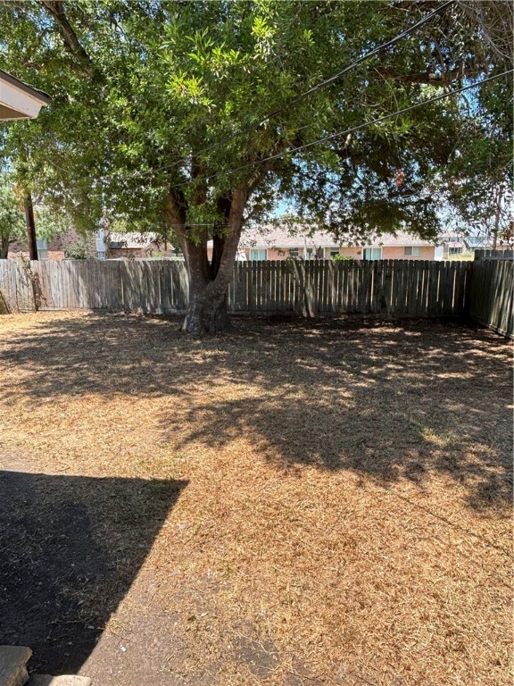 1141 Austin Street Portland, TX 78374 - Photo 10 of 10 a view of a backyard with large trees and wooden fence