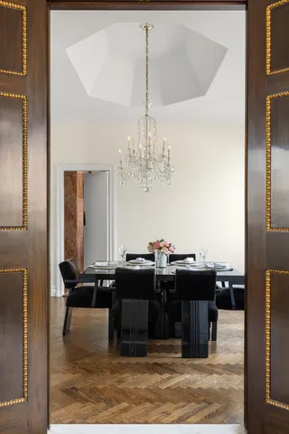 a living room with furniture kitchen view and a chandelier