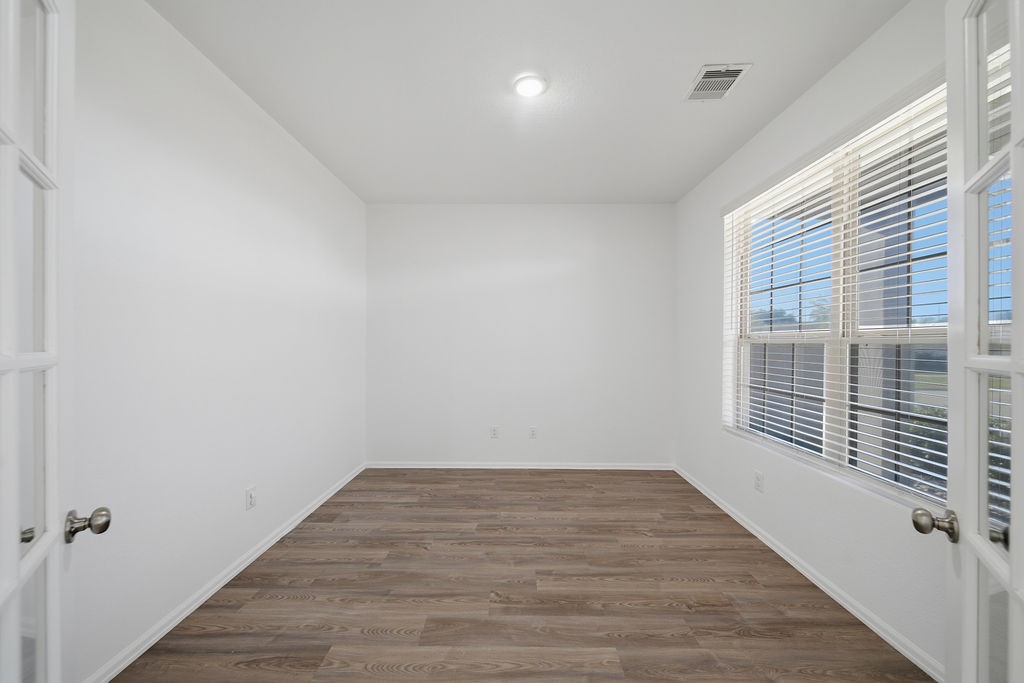 14230 Overbrook Willow Way Rosharon, TX 77583 - Photo 6 of 50 a view of an empty room with wooden floor and a window