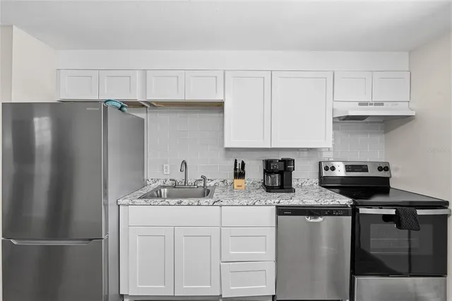 a kitchen with stainless steel appliances granite countertop a refrigerator sink and cabinets