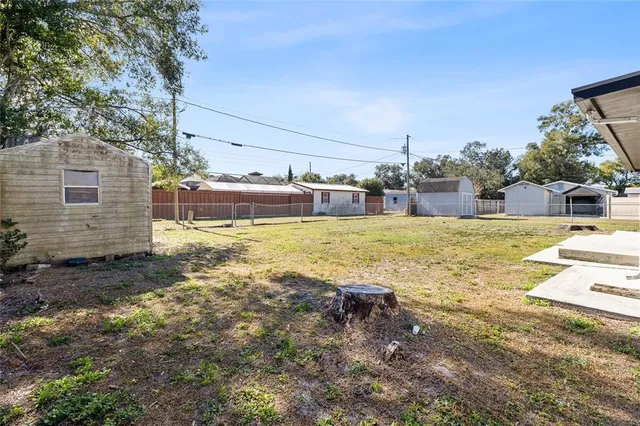 a view of house with backyard and trees
