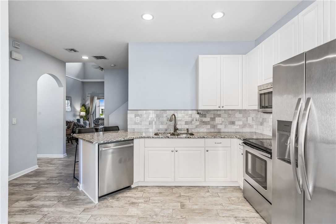 2522 Stockbridge Square Southwest Vero Beach, FL 32962 - Photo 14 of 34 a kitchen with stainless steel appliances granite countertop a sink stove and refrigerator