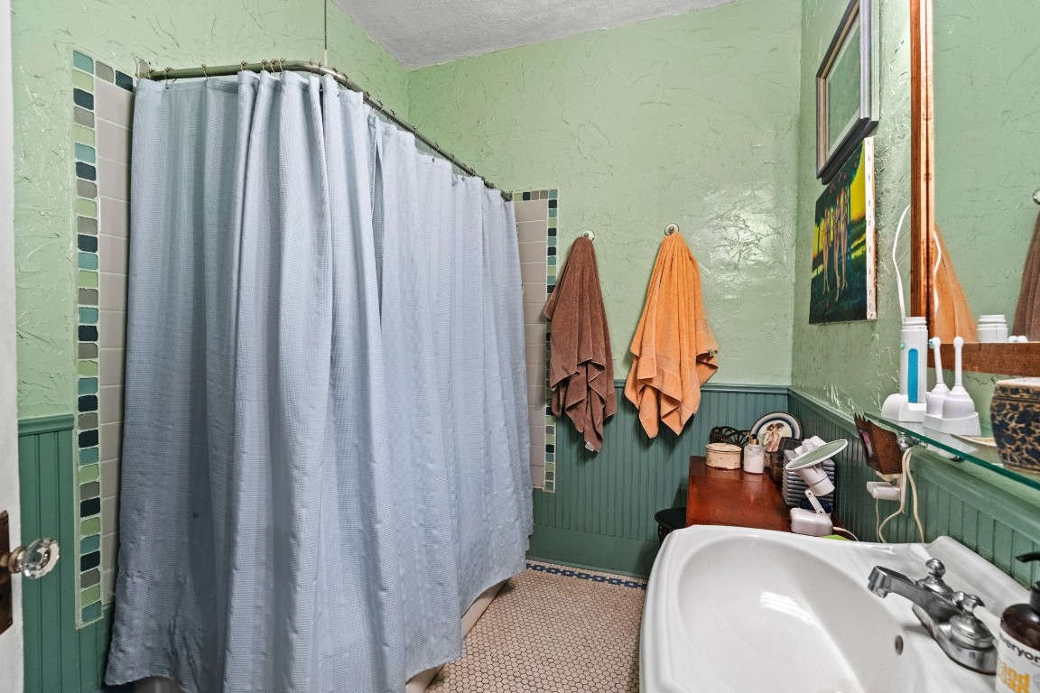 1004 Missouri Street Houston, TX 77006 - Photo 16 of 22 a bathroom with a sink a mirror and shower curtain