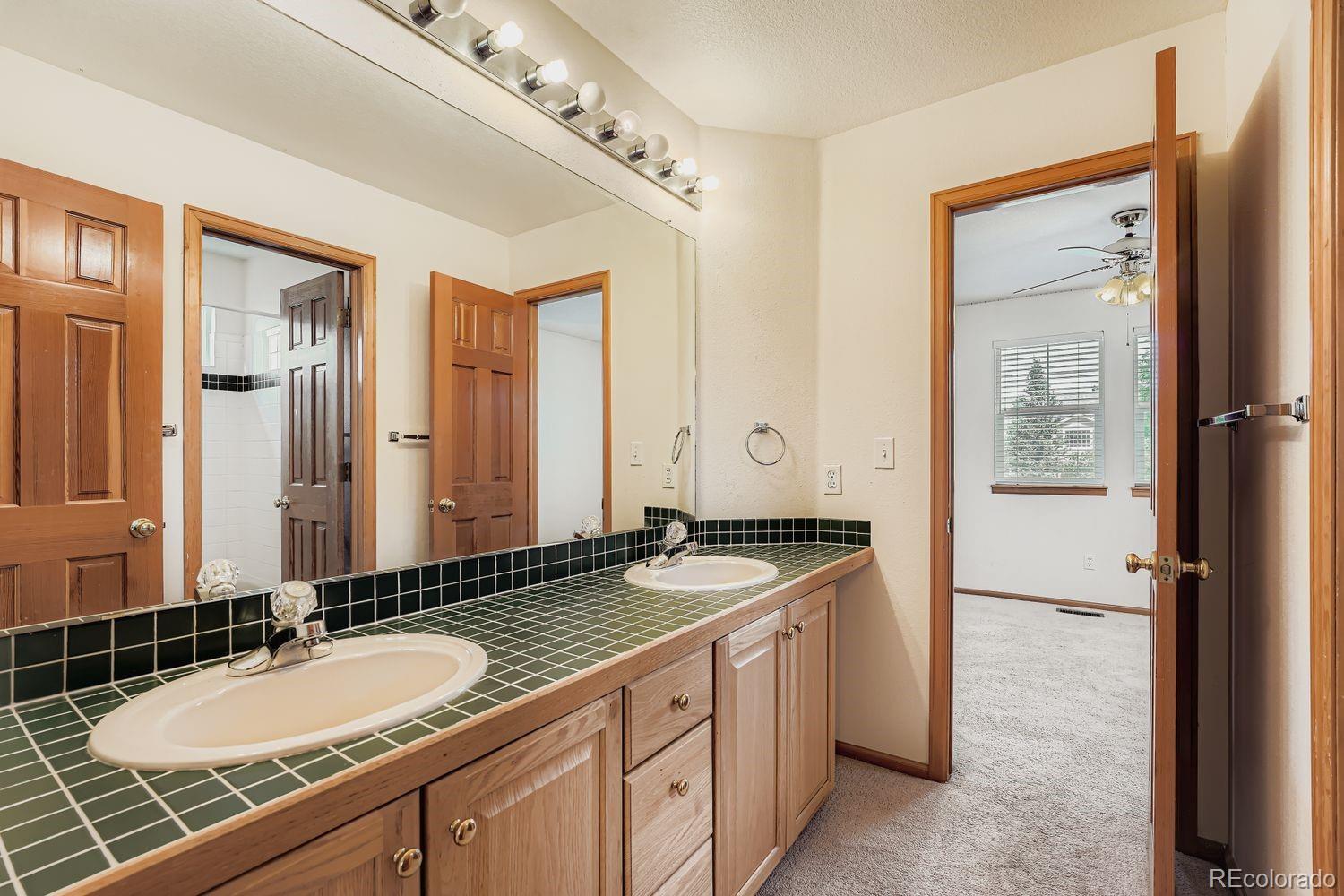 20758 East Maplewood Lane Centennial, CO 80016 - Photo 20 of 29 a bathroom with a granite countertop double vanity sink and mirror