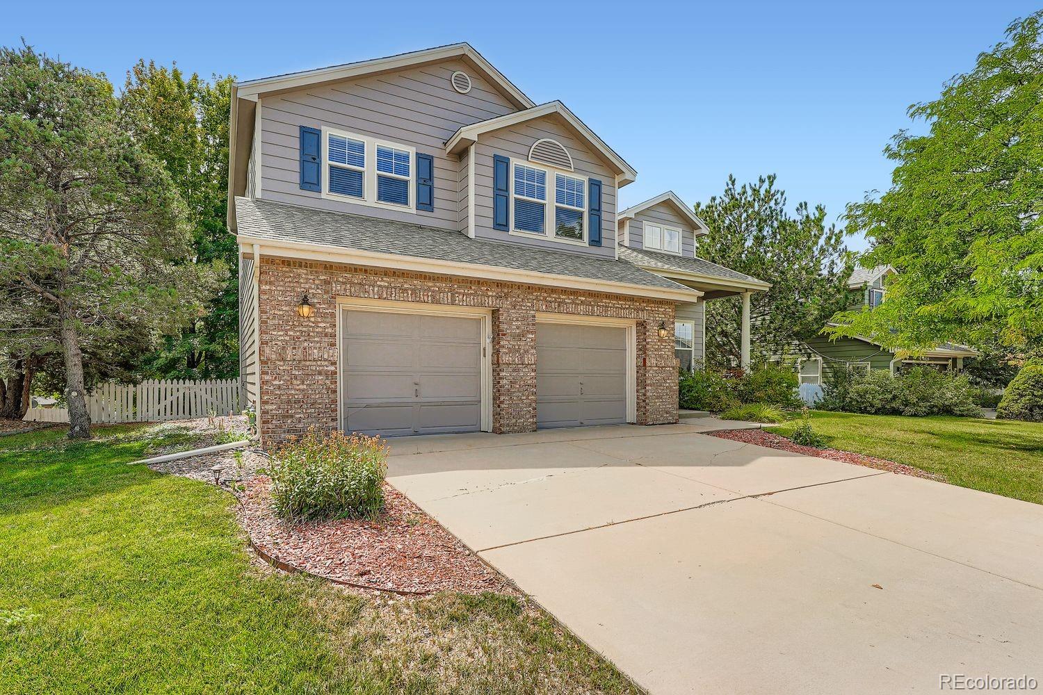 20758 East Maplewood Lane Centennial, CO 80016 - Photo 2 of 29 a front view of a house with a yard and garage