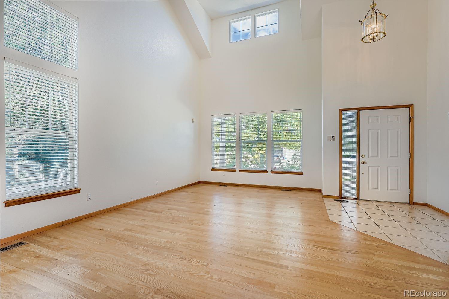20758 East Maplewood Lane Centennial, CO 80016 - Photo 6 of 29 a view of an empty room with wooden floor and a window